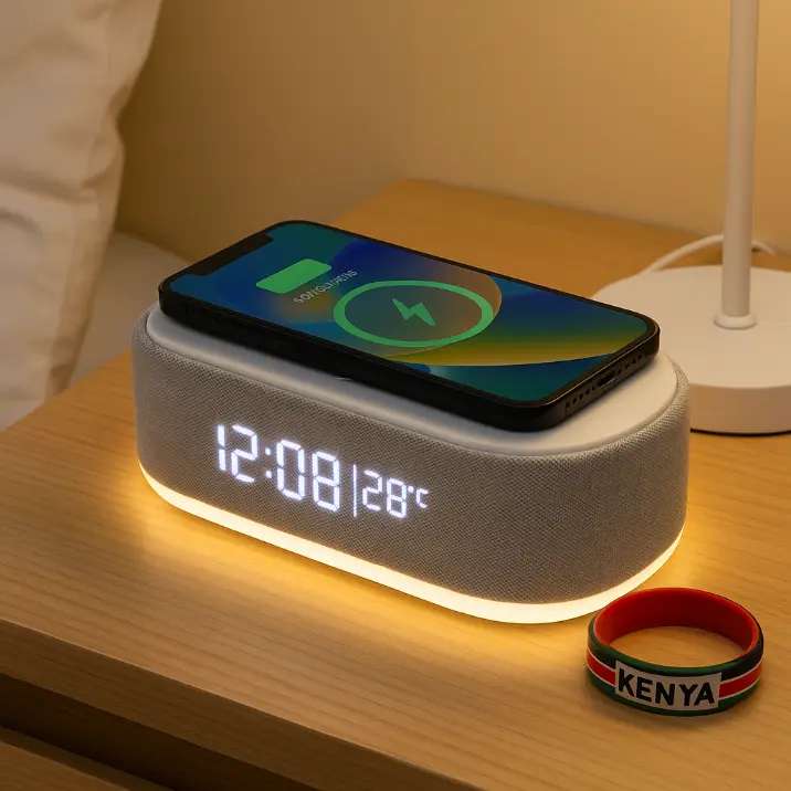 Smart LED digital clock with wireless phone charging, Bluetooth speaker, temperature display, and night light on a bedside table, with a Kenyan flag wristband placed beside it